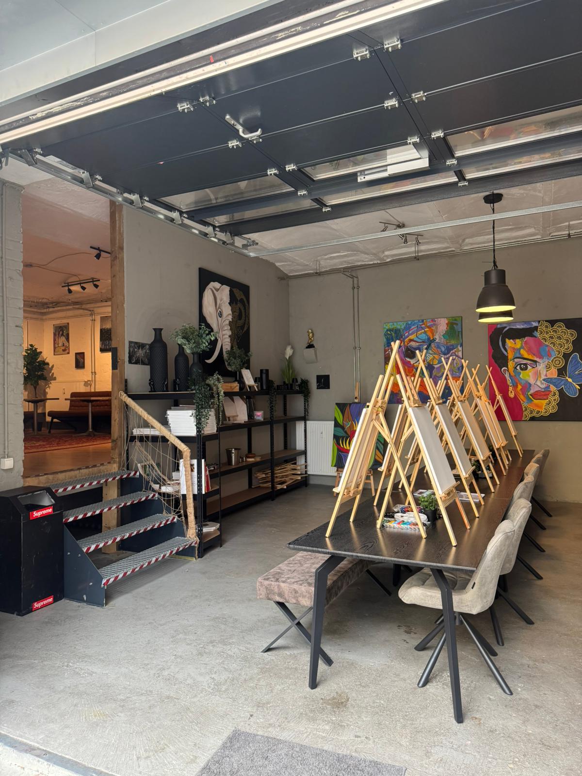 Workshop-Raum mit Staffeleien und Elefanten-Kunstwerk an der Wand